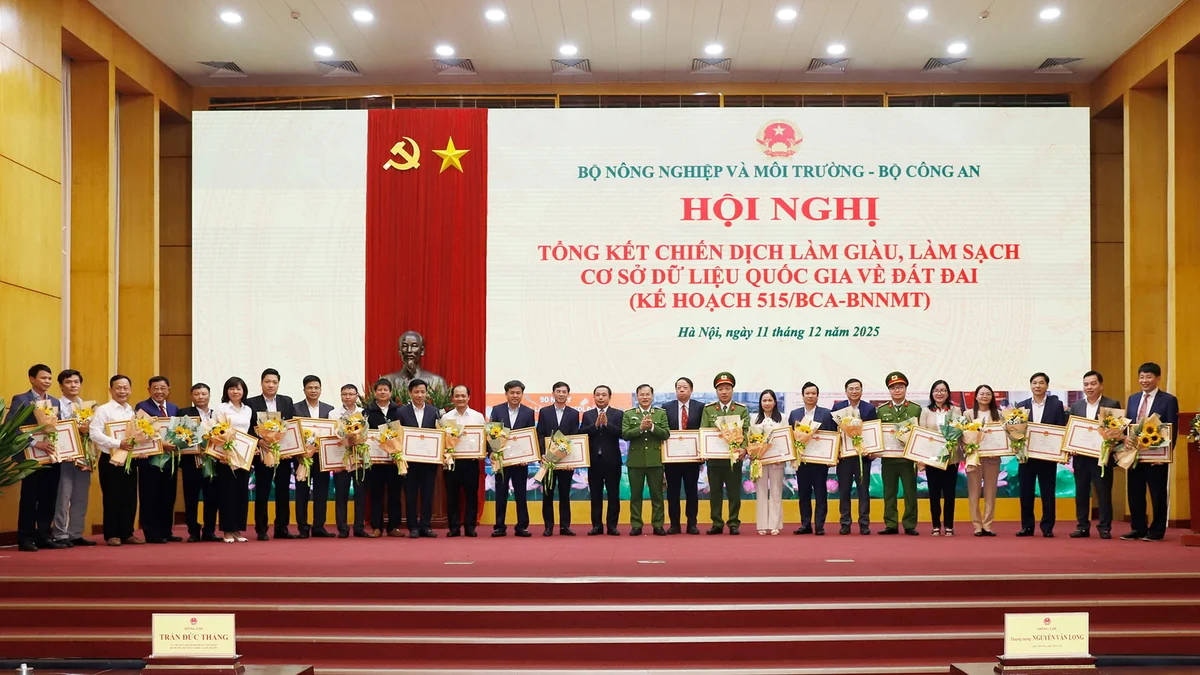 Bộ trưởng Trần Đức Thắng và Thứ trưởng Nguyễn Văn Long tặng bằng khen cho các đơn vị có thành tích xuất sắc trong thực hiện phong trào thi đua 'Làm giàu, làm sạch cơ sở dữ liệu quốc gia về đất đai'. Ảnh: Khương Trung.